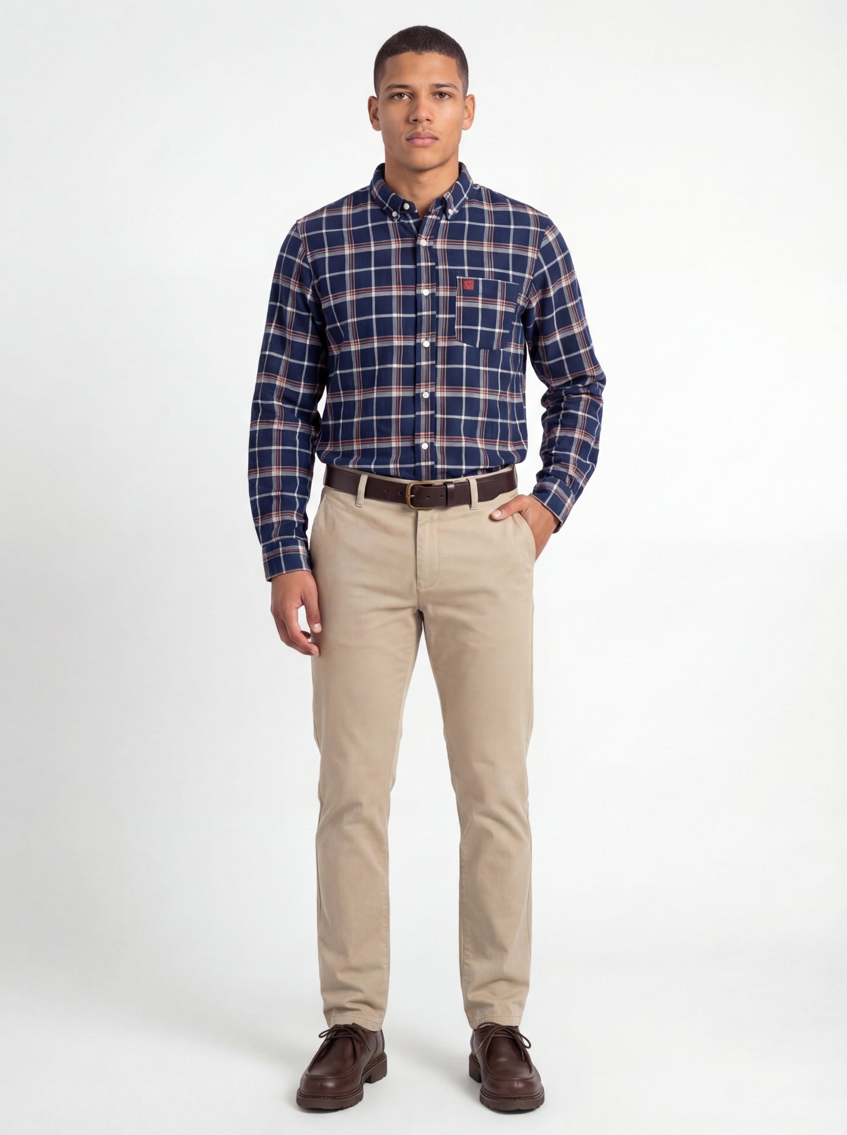 Man wearing a plaid shirt and beige pants on a white background